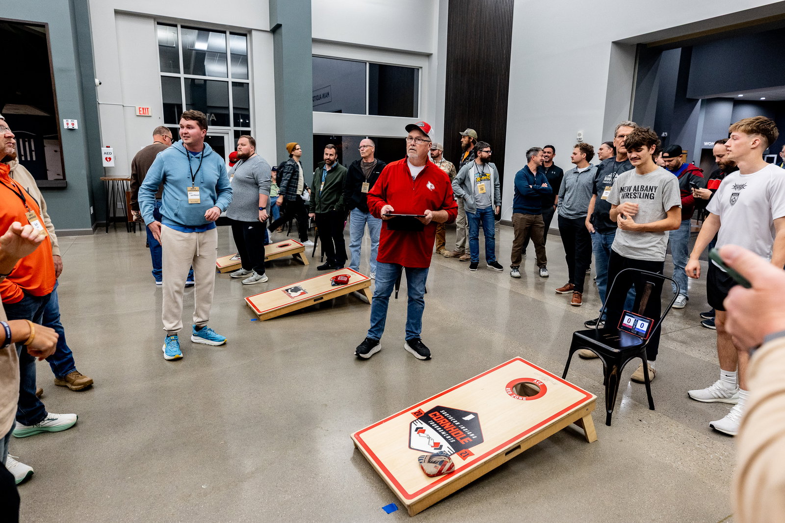 Men gathered around a cornhole tournament at Men's Conference